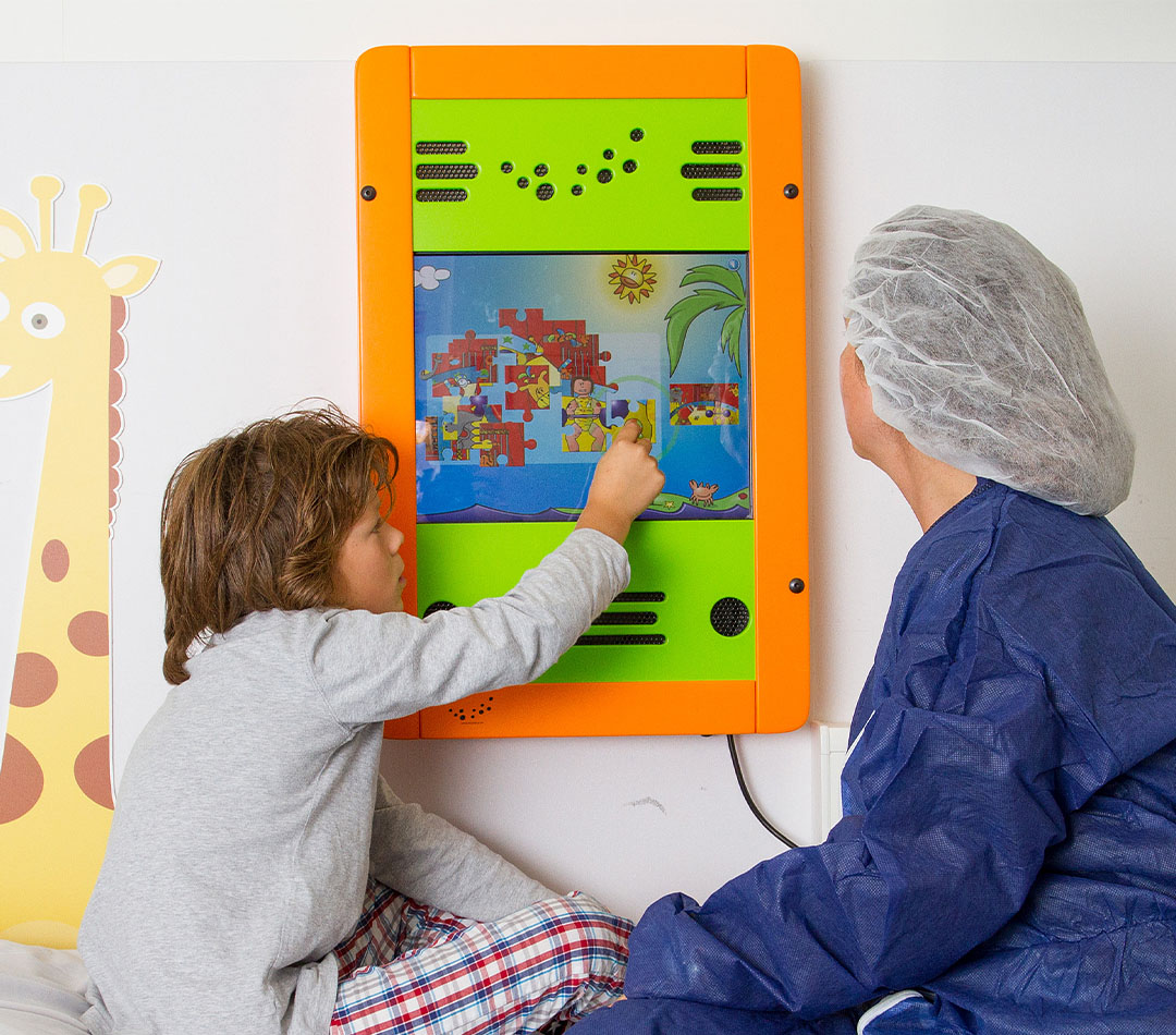 Kind en zorgverlener spelen met wandspel in ziekenhuis