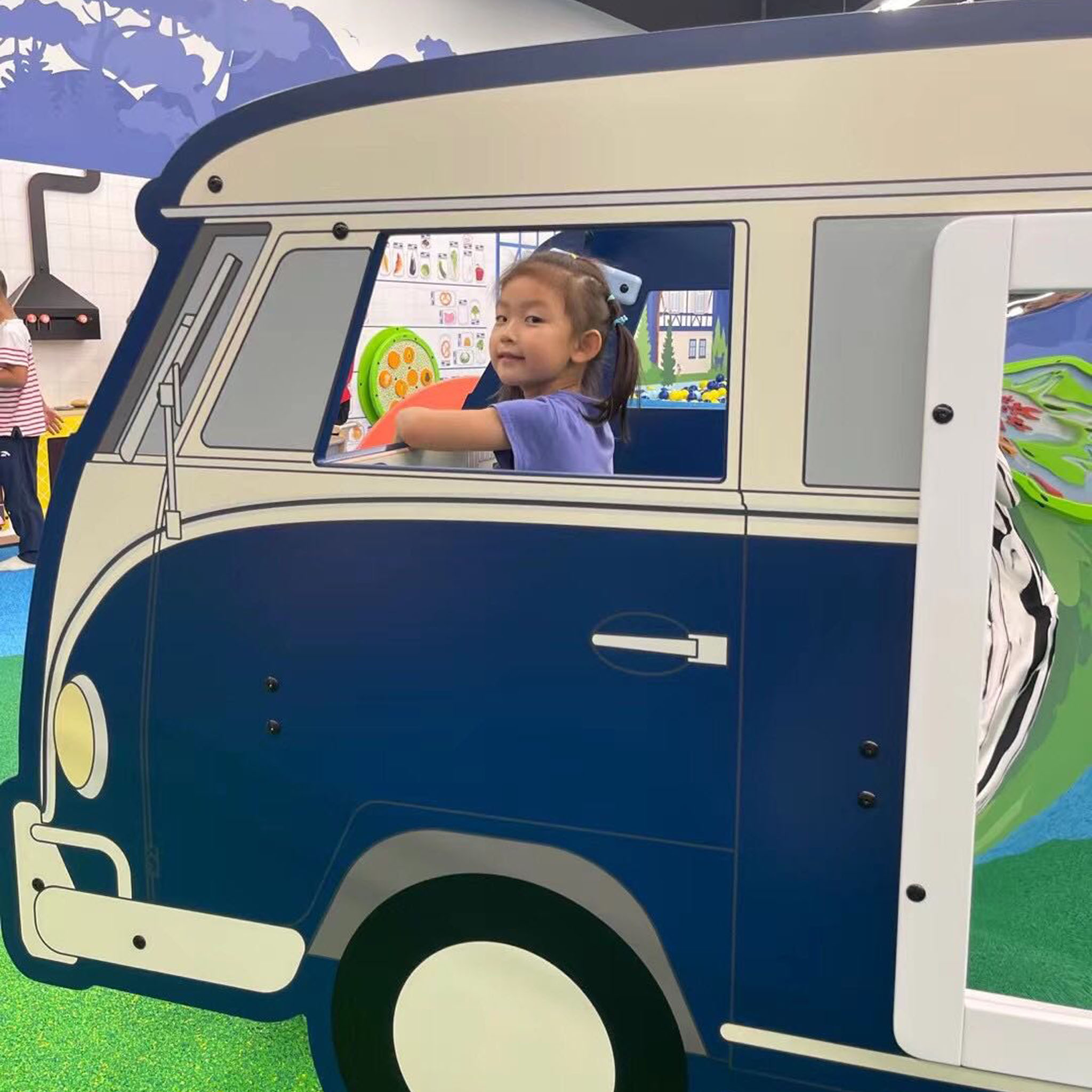 A young girl playing in a play system from IKC in the form of a van