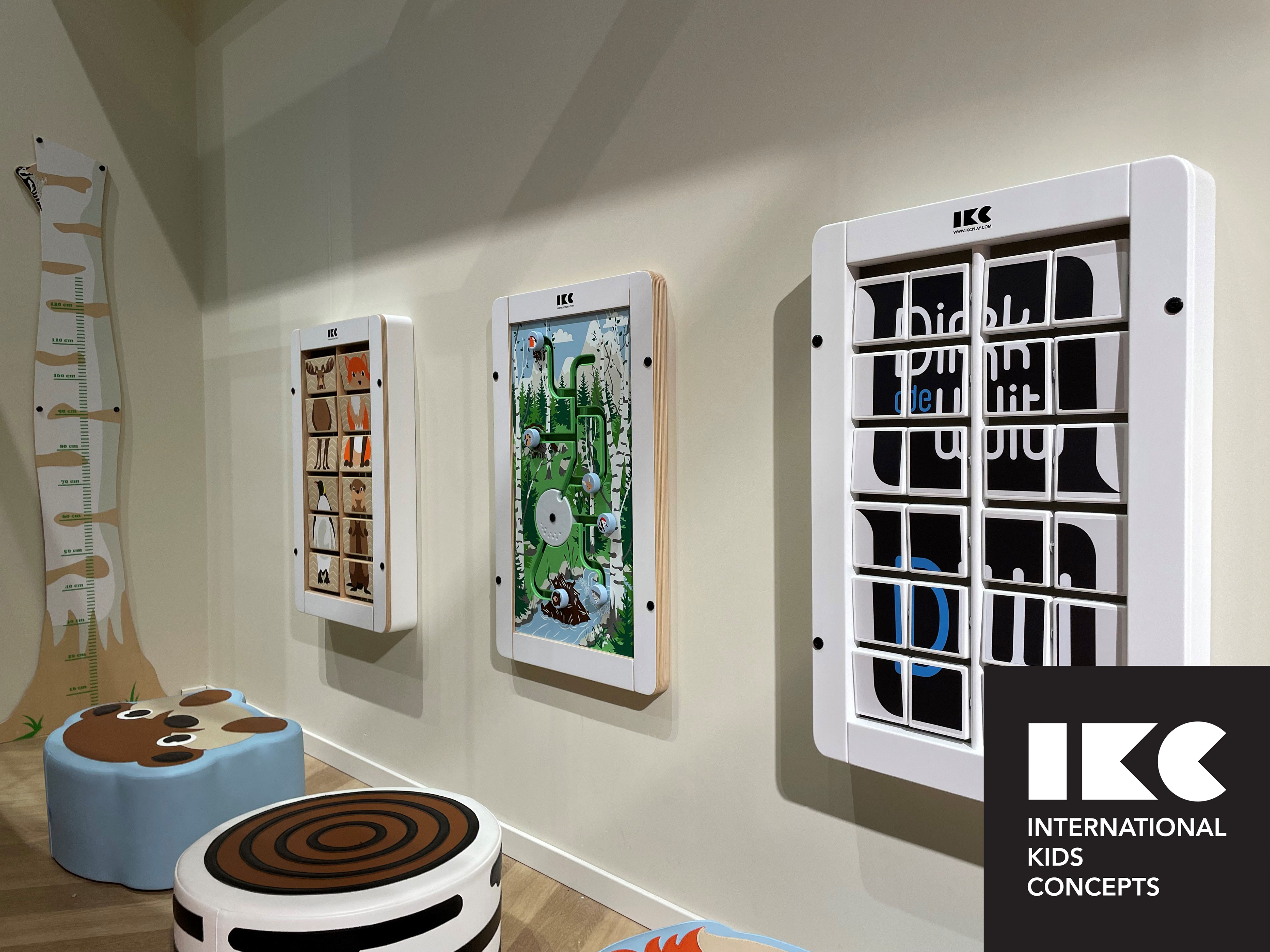 Wall-mounted play panels in a modern children's corner by IKC, designed for public waiting areas