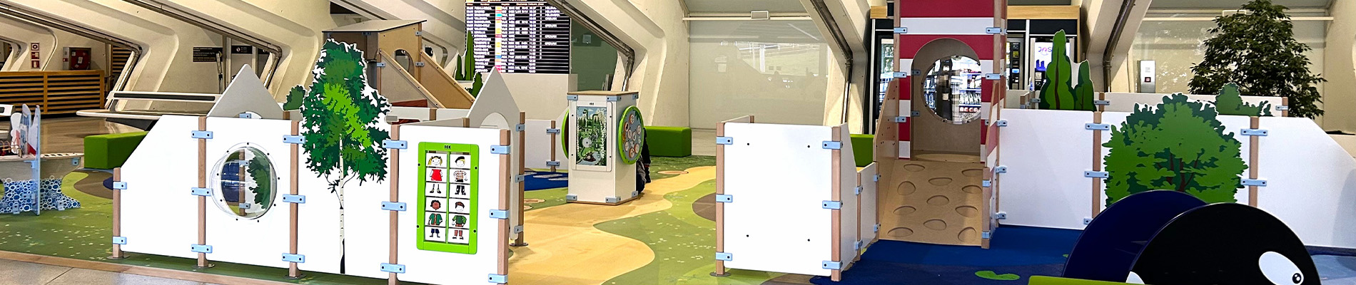 Overzicht van de maritiem gethematiseerde kinderspeelhoek op Bilbao Airport, met klimelementen, interactieve spellen en comfortabele zitplekken voor ouders.