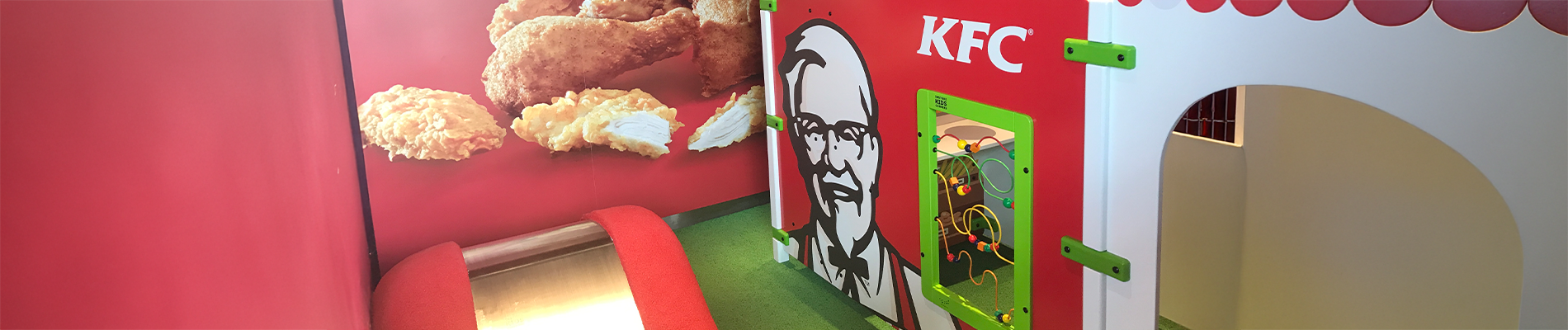 Kinderhoek bij KFC met een speelsysteem en interactieve speelwand, zodat kinderen veilig kunnen spelen terwijl ouders genieten van hun maaltijd.